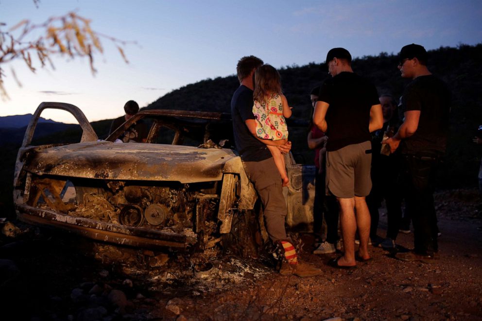 PHOTO: Relatives of slain members of Mexican-American families belonging to Mormon communities observe the burnt wreckage of a vehicle where some of their relatives died, in Bavispe, Sonora state, Mexico Nov. 5, 2019. 