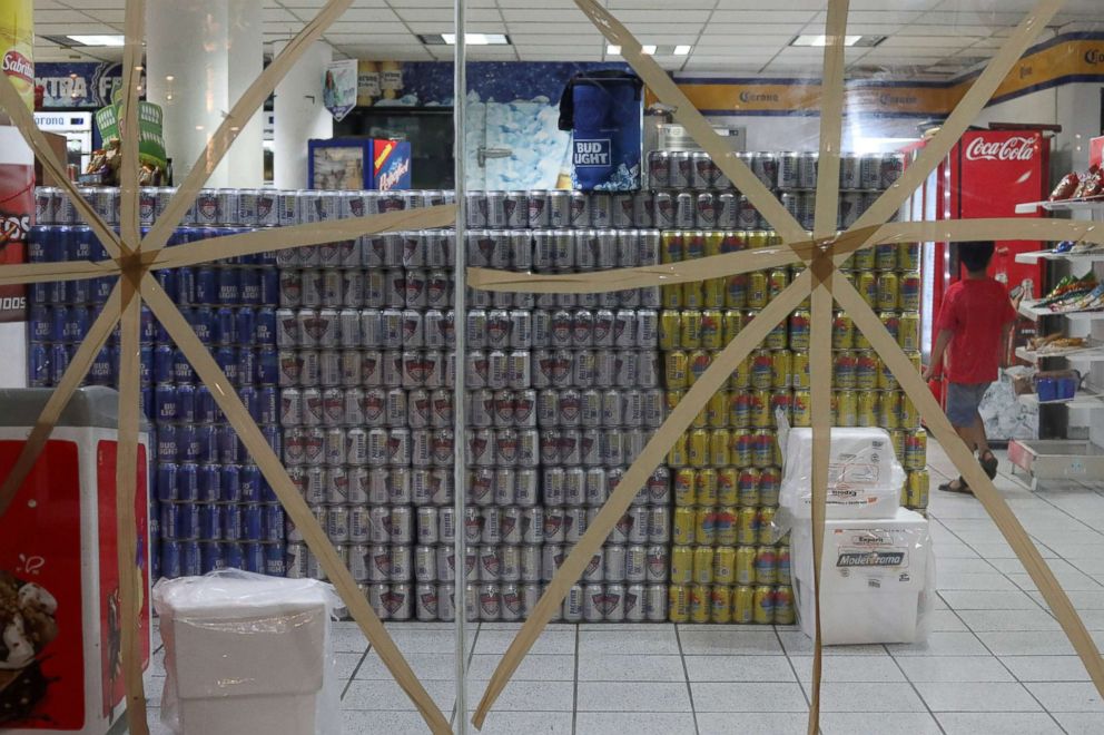 PHOTO: A boy walks inside a store with taped-up glass panels, to protect against the expected severe winds of Hurricane Willa, as it approaches the Pacific beach resort of Mazatlan, Mexico, Oct. 22, 2018.