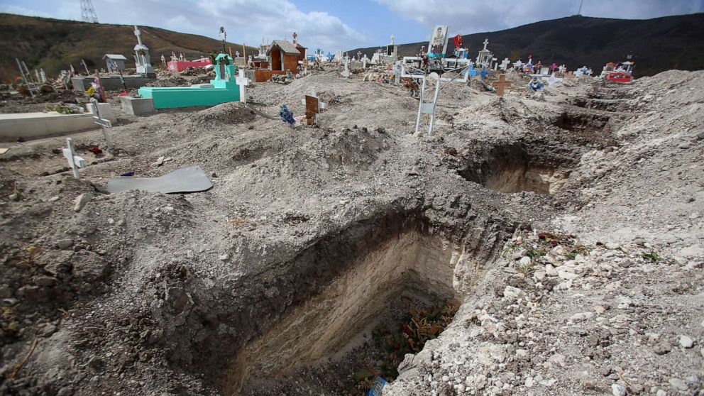 PHOTO: Open pits are pictured next to graves of victims of COVID-19, and of others, at the municipal cemetery No. 12 in Tijuana, Mexico, May 21, 2021. 
