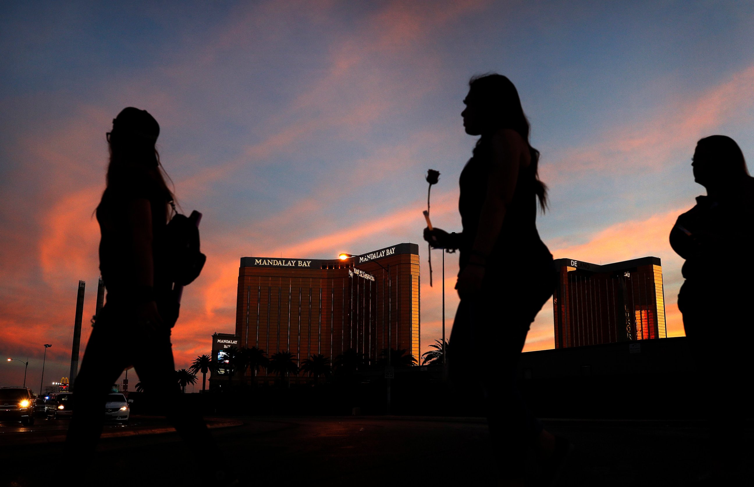 PHOTO: In this April 1, 2018, file photo, people carry flowers as they walk near the Mandalay Bay hotel and casino during a vigil for victims and survivors of a mass shooting in Las Vegas.