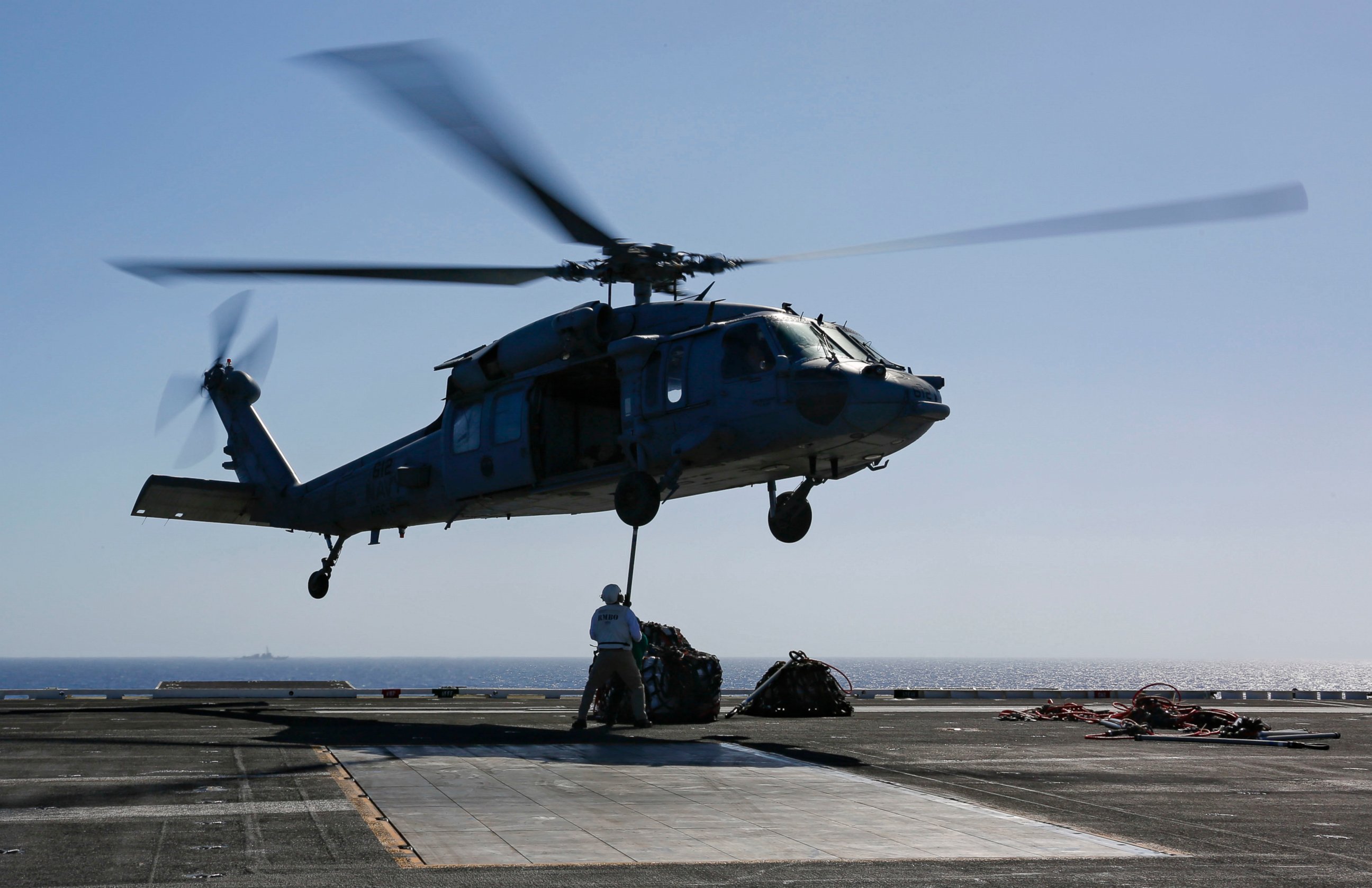 PHOTO: In this Friday, May 10, 2019, photo released by the U.S. Navy, logistics specialists attach cargo to an MH-60S Sea Hawk helicopter on the flight deck of the Nimitz-class aircraft carrier USS Abraham Lincoln in the Persian Gulf.