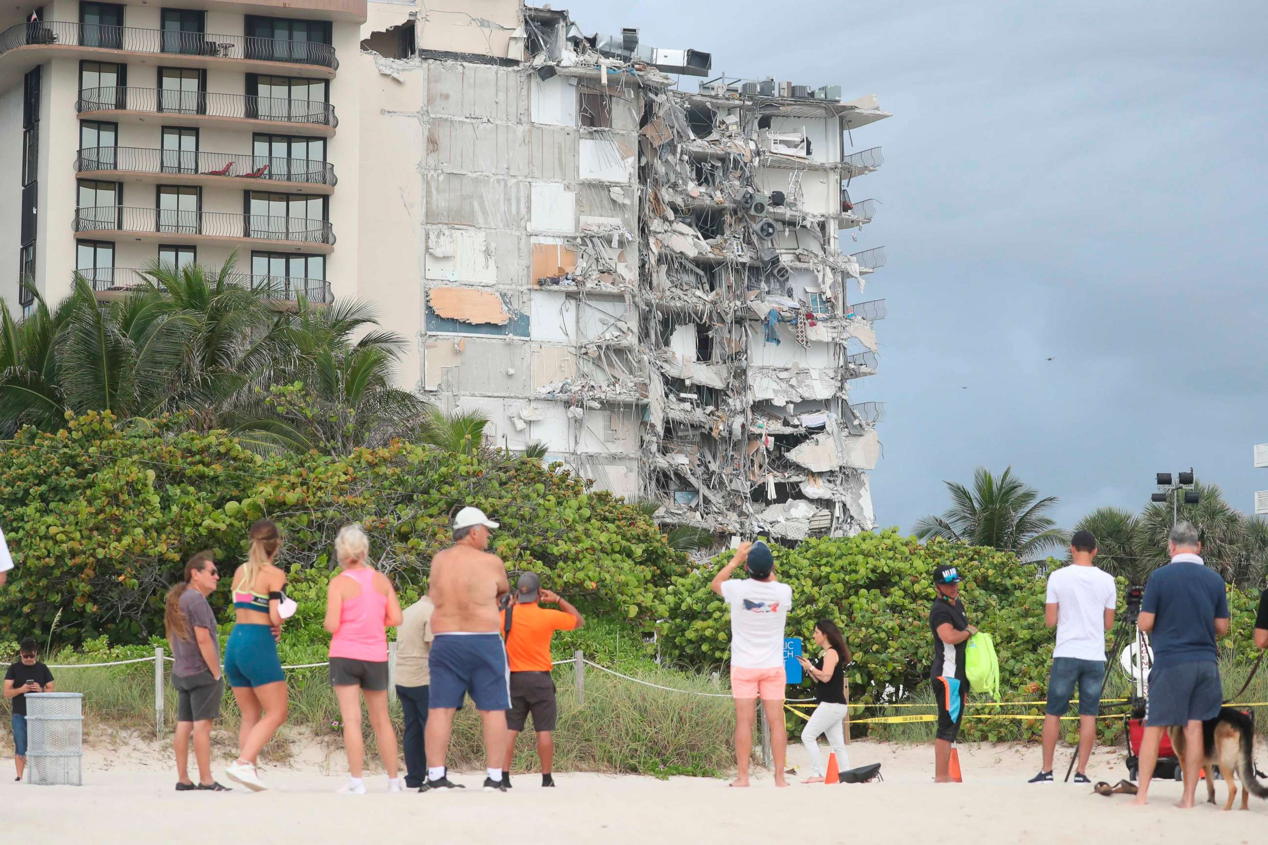 PHOTO: People look at the damage at the 12-story oceanfront Champlain Towers South Condo that collapsed early Thursday, June 24, 2021, in Surfside, Fla.