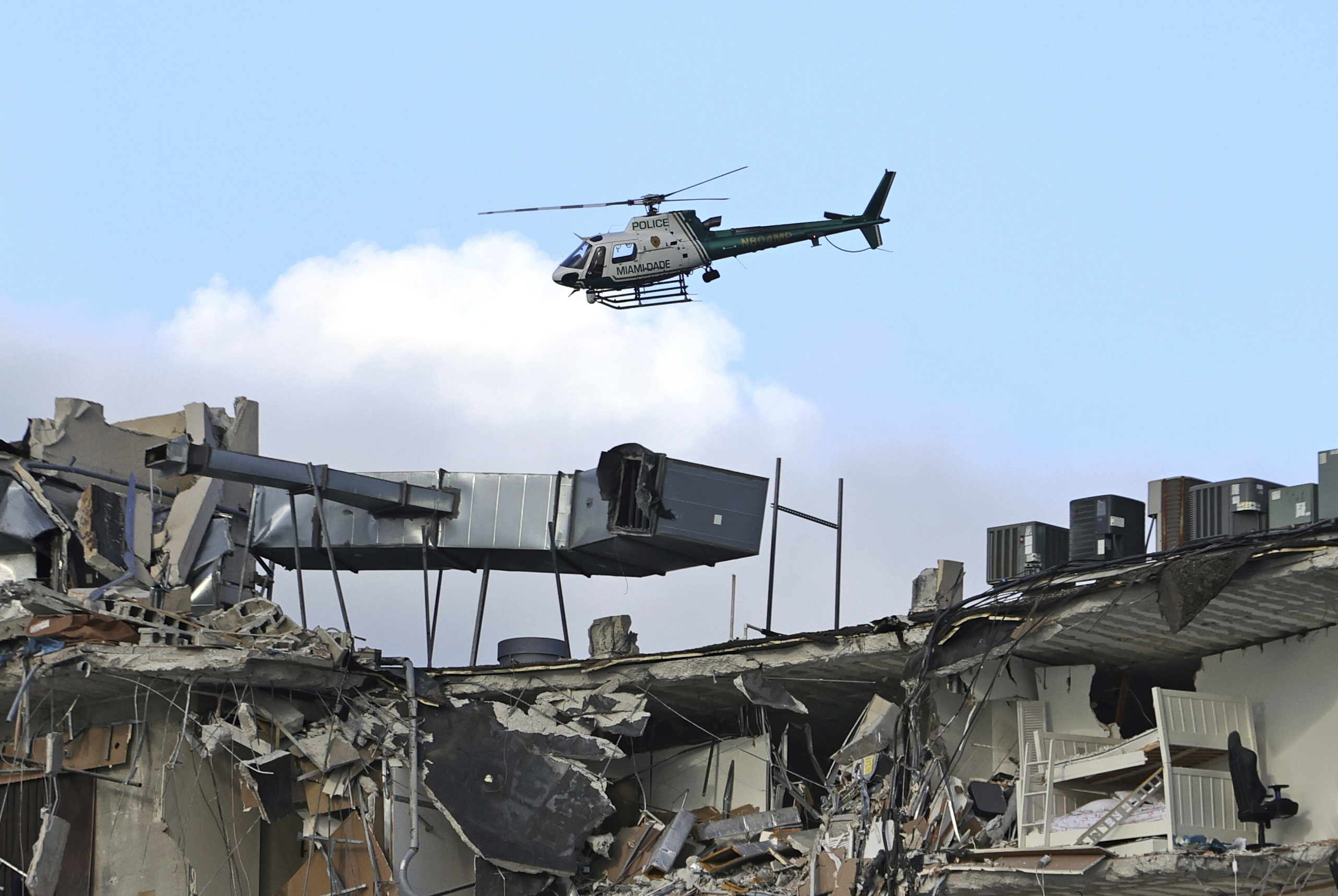 PHOTO: A Miami-Dade Police helicopter flies over the Champlain Towers South Condo after the multistory building partially collapsed, June 24, 2021, in Surfside, Fla.