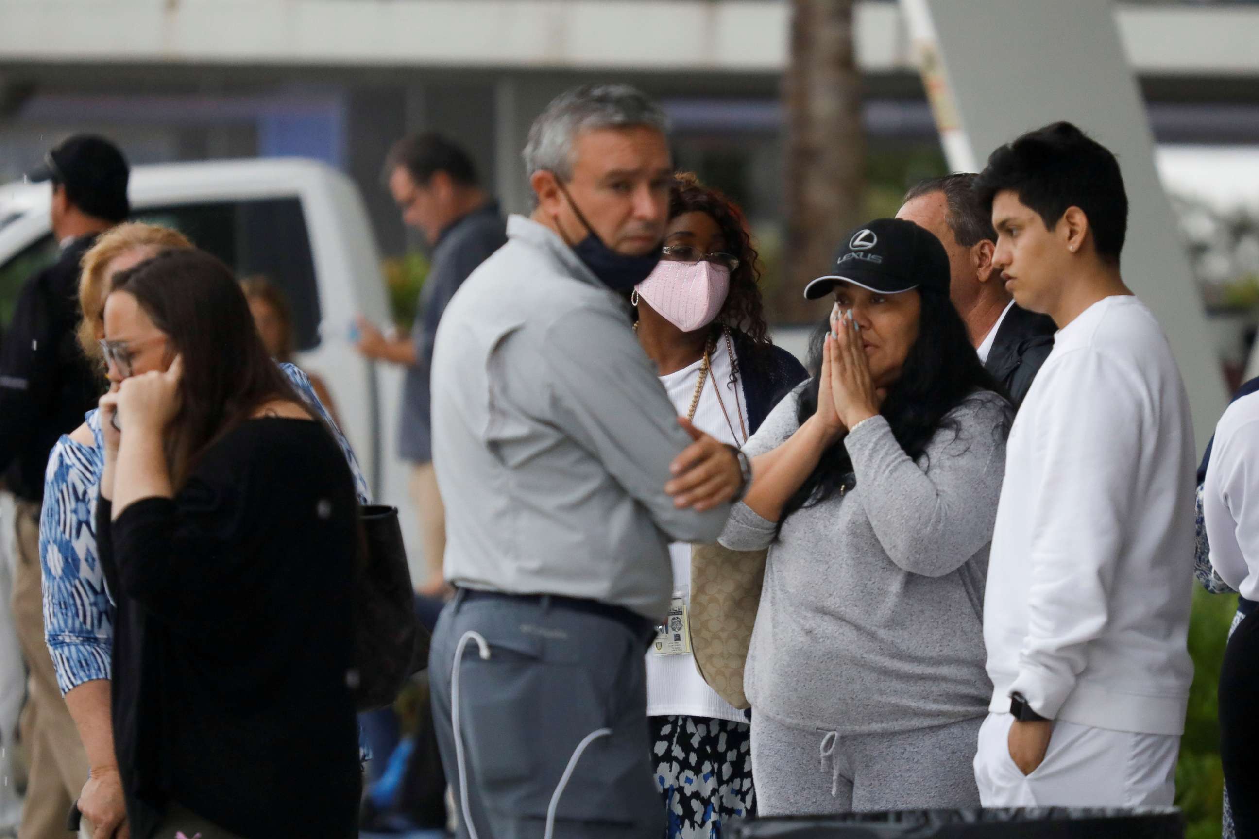 PHOTO: People stand at the Surfside Community Center where authorities are taking residents and relatives from a partially collapsed building in Surfside near Miami Beach, Fla., June 24, 2021.