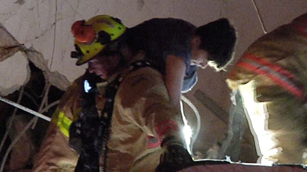 PHOTO: In an image made from video provided by ReliableNewsMedia, firefighters rescue a survivor from the rubble of the Champlain Towers South Condo after the multistory building partially collapsed in Surfside, Fla., early Thursday, June 24, 2021.