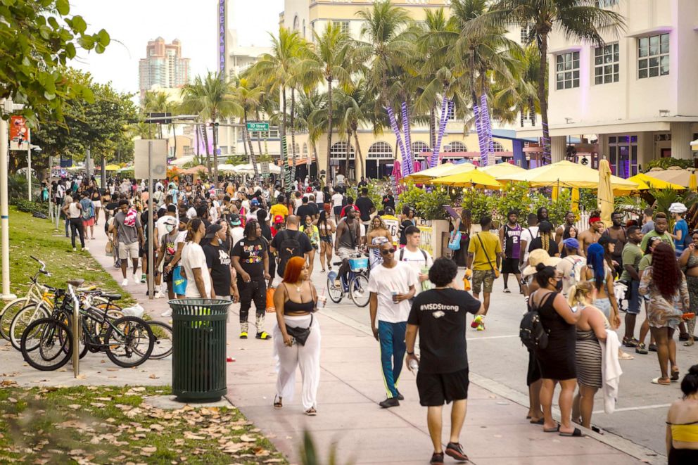 PHOTO: A crowd of people walk along Ocean Drive in the South Beach neighborhood of Miami on March 27, 2021.
