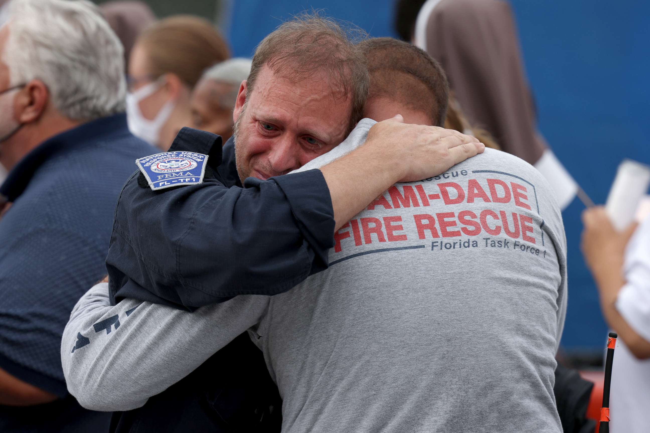 PHOTO: Rescue workers with the Miami-Dade Fire Rescue embrace after a moment of silence was held for the victims of the collapsed Champlain Towers South condominium in Surfside, Florida, on July 7, 2021.