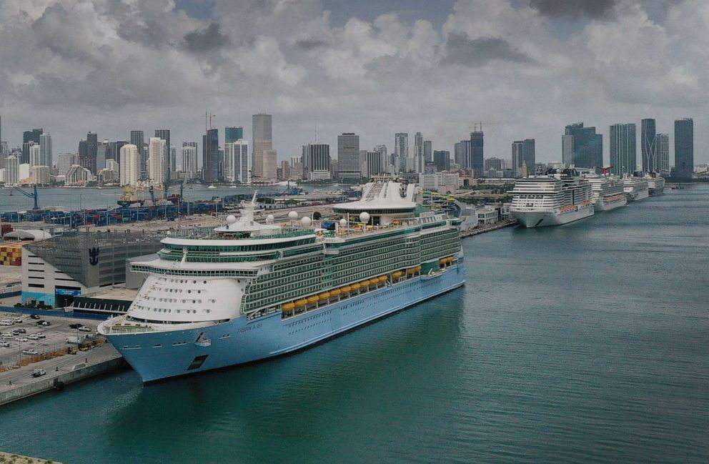 PHOTO: In an aerial view, the Royal Caribbean Freedom of the Seas (L) prepares to set sail from Port Miami during the first U.S. trial cruise testing COVID-19 protocols, June 20, 2021, in Miami, Fla.