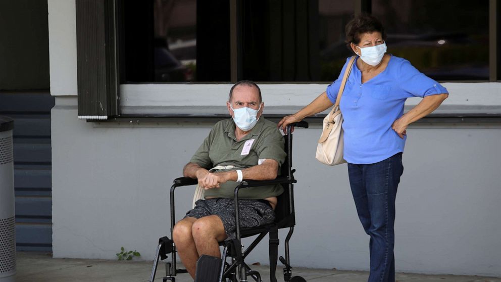 PHOTO: People wearing protective masks are seen outside Jackson Memorial Hospital, as Miami-Dade County eases some of the lockdown measures put in place during the coronavirus disease outbreak, in Miami, June 18, 2020.