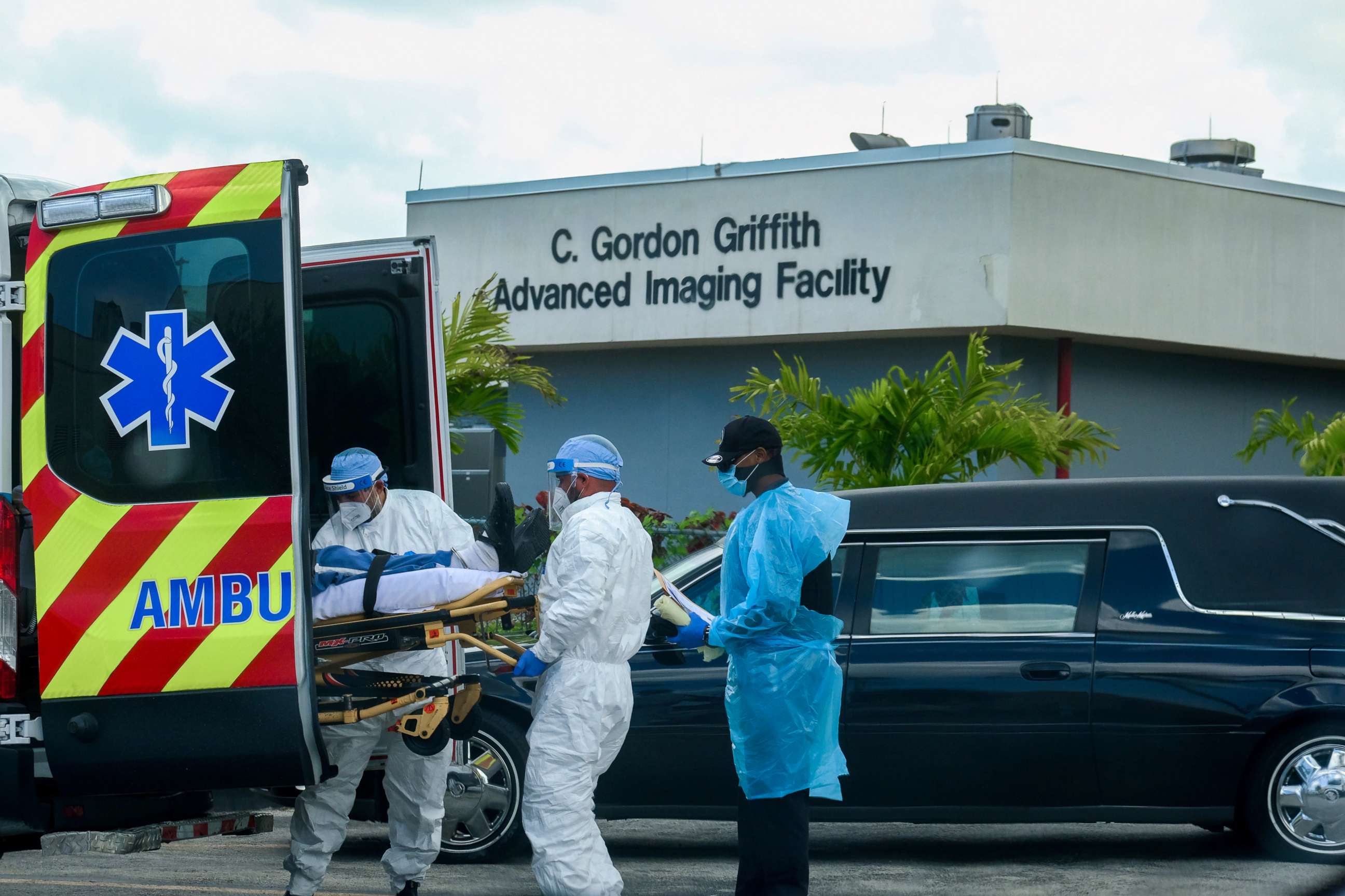 PHOTO: Emergency Medical Technicians arrive with a patient while a funeral car begins to depart at North Shore Medical Center where coronavirus disease patients are treated, in Miami, July 14, 2020.