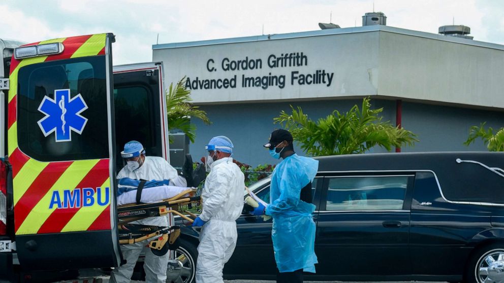 PHOTO: Emergency Medical Technicians (EMT) arrive with a patient while a funeral car begins to depart at North Shore Medical Center where  coronavirus disease (COVID-19) patients are treated, in Miami, July 14, 2020.