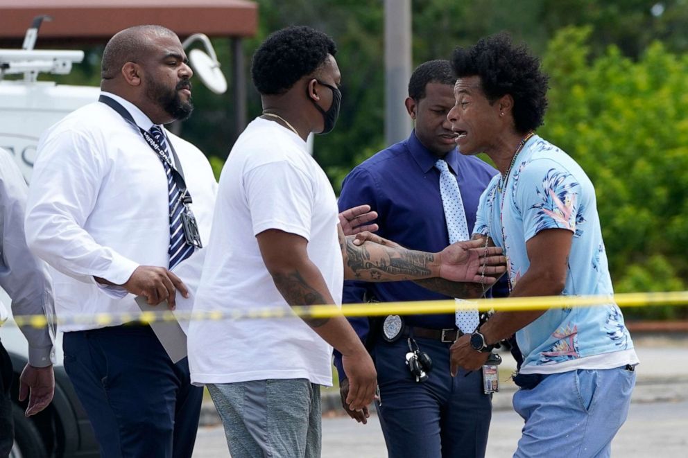 PHOTO: Clayton Dillard, right, talks with a police official, left, seeking information about a family member outside of the scene of a shooting at a banquet hall near Hialeah, Fla., May 30, 2021.