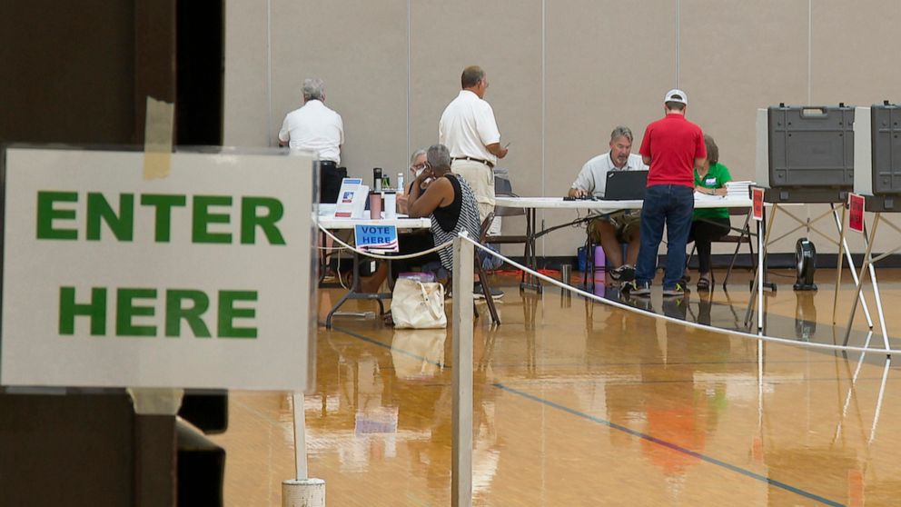 PHOTO: Poll workers assist voters at a precinct in Delhi Township, Mich., near Lansing, Aug. 2, 2022.