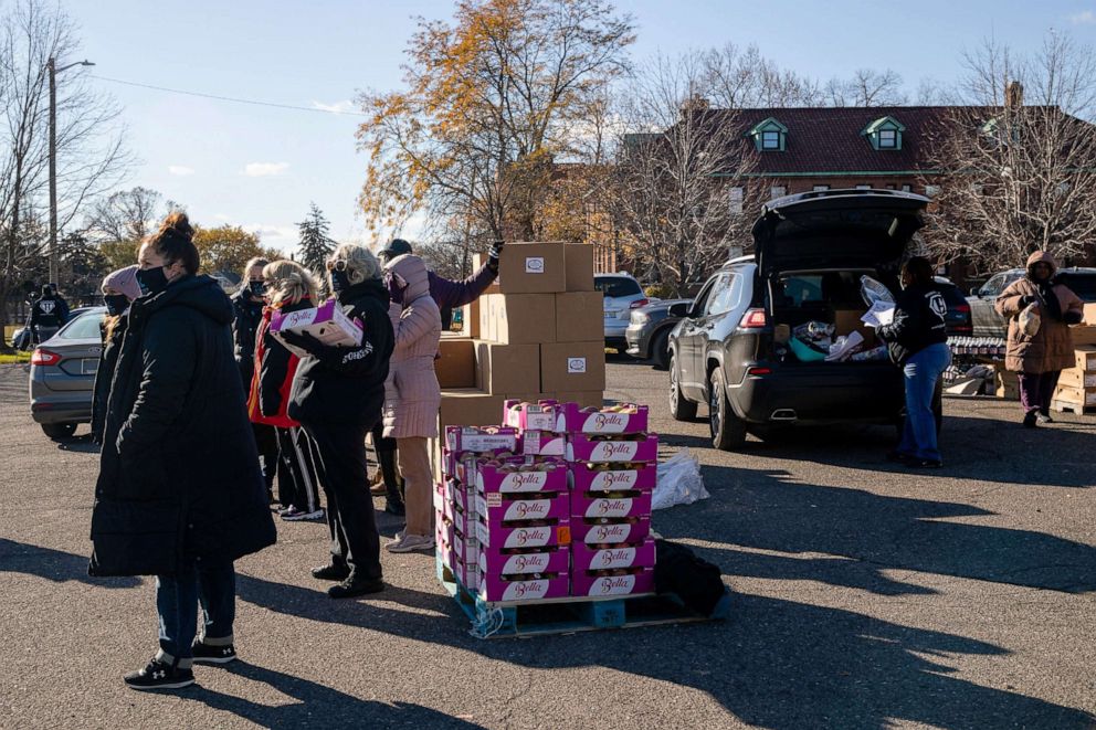 PHOTO: Volunteers from a local nonprofit distribute Thanksgiving meals to families during a drive through event, in Detroit, Nov. 22, 2021. 