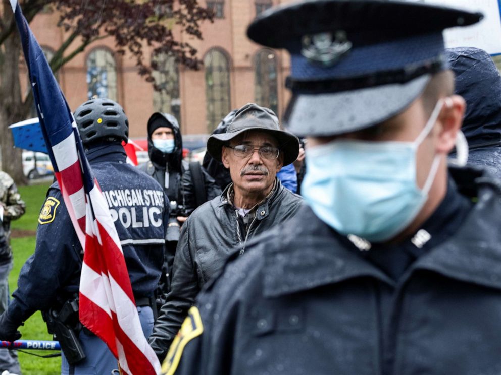 PHOTO: A man is surrounded by police officers after a small scuffle during a protest against Governor Gretchen Whitmer's extended stay-at-home orders intended to slow the spread of the coronavirus disease at the Capitol in Lansing, Mich., May 14, 2020.