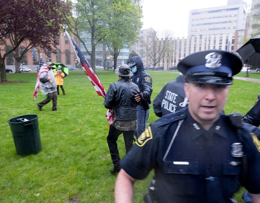 PHOTO: A man is surrounded by police officers after a small scuffle during a protest against Governor Gretchen Whitmer's extended stay-at-home orders intended to slow the spread of the coronavirus disease at the Capitol in Lansing, Mich., May 14, 2020.