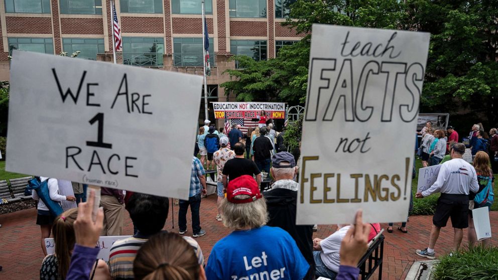 PHOTO: People hold up signs during a rally against "critical race theory" (CRT) being taught in schools at the Loudoun County Government center in Leesburg, Va., June 12, 2021.