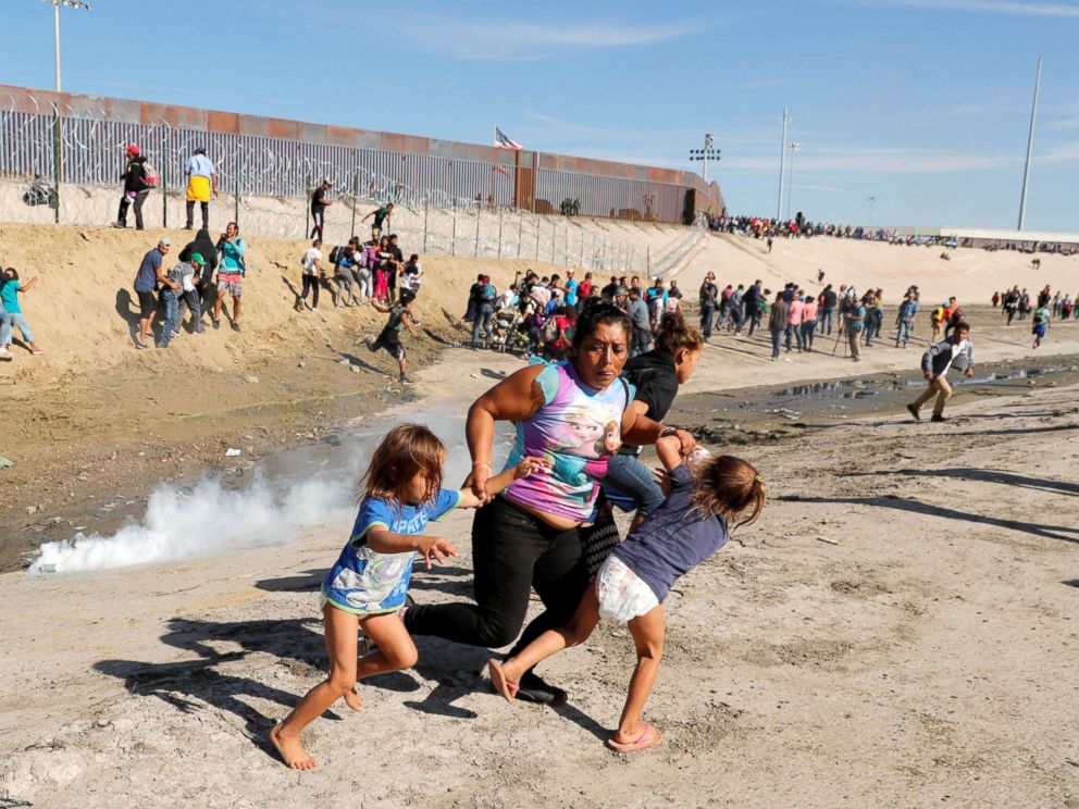 PHOTO: Maria Meza runs away from tear gas with her five-year-old twin daughters Saira Mejia Meza, left, and Cheili Mejia Meza in front of the border wall between the U.S. and Mexico, in Tijuana, Nov. 25, 2018.