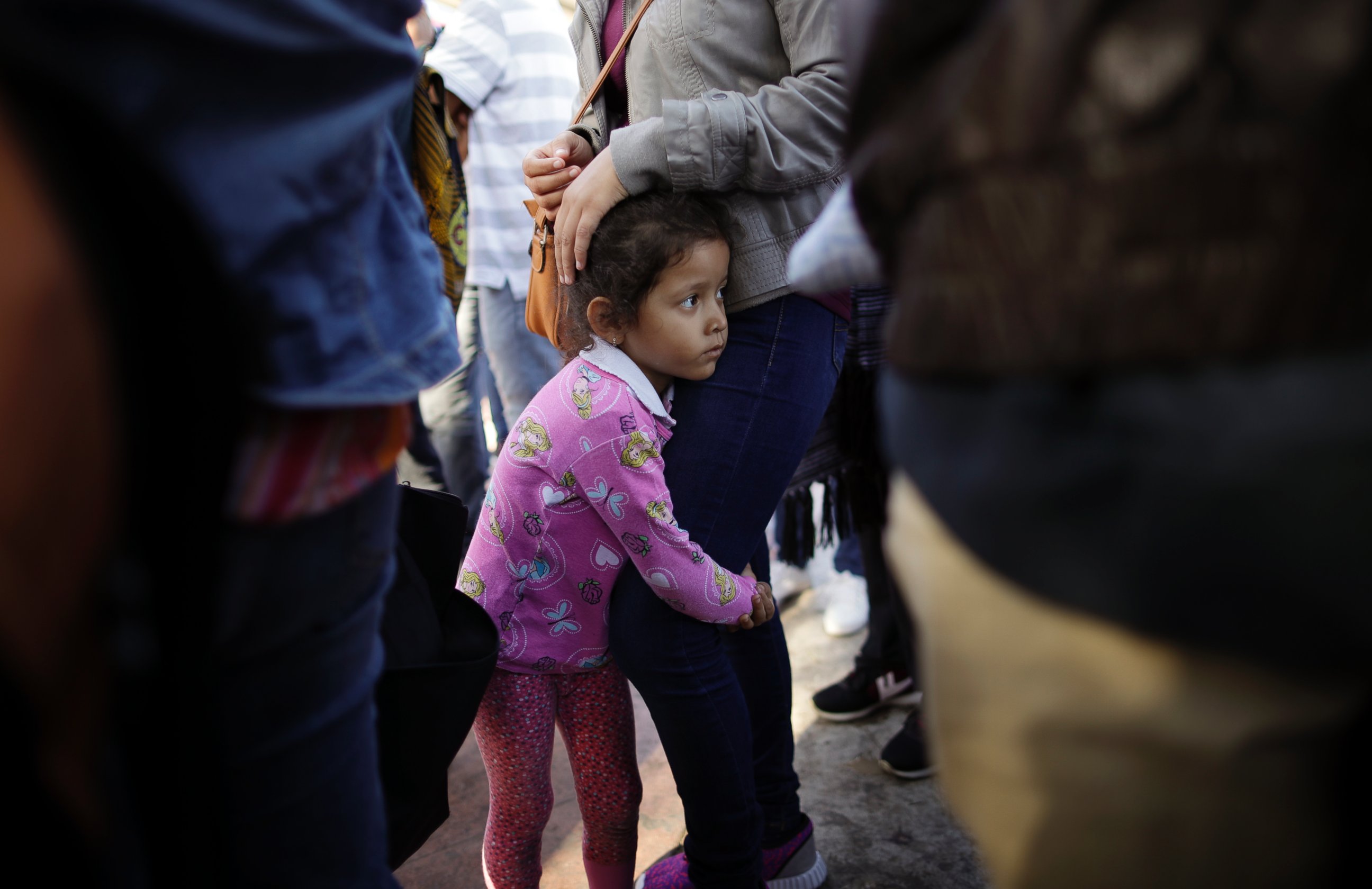 In this June 13, 2018 file photo, Nicole Hernandez, of the Mexican state of Guerrero, holds on to her mother as they wait with other families to request political asylum in the United States, across the border in Tijuana, Mexico.