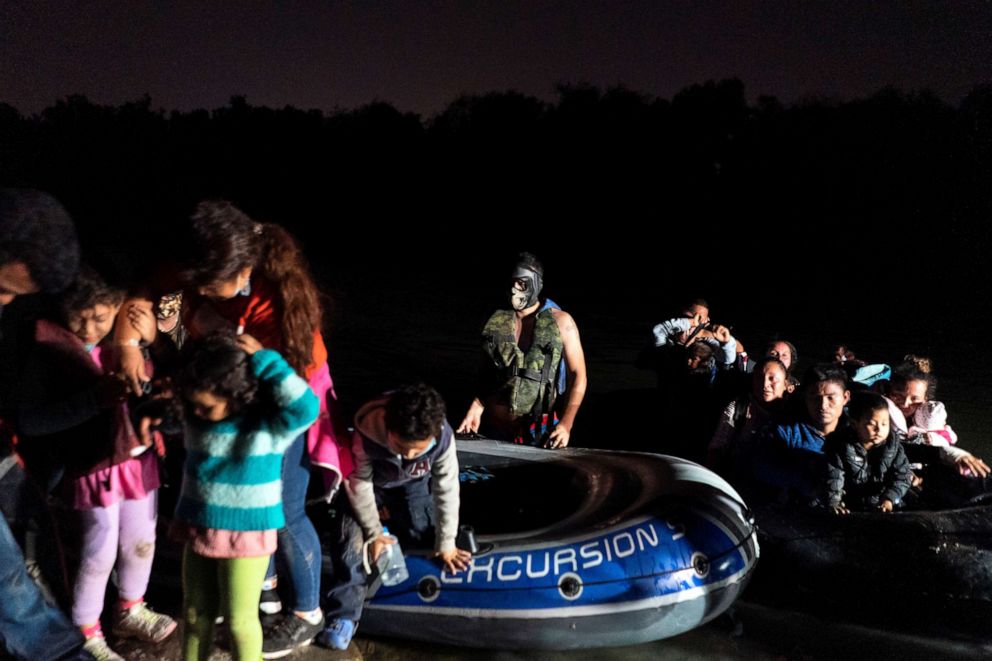 PHOTO: Asylum-seeking migrant families disembark from an inflatable raft in Roma, Texas, on April 7, 2021, after crossing the Rio Grande river into the United States from Mexico.