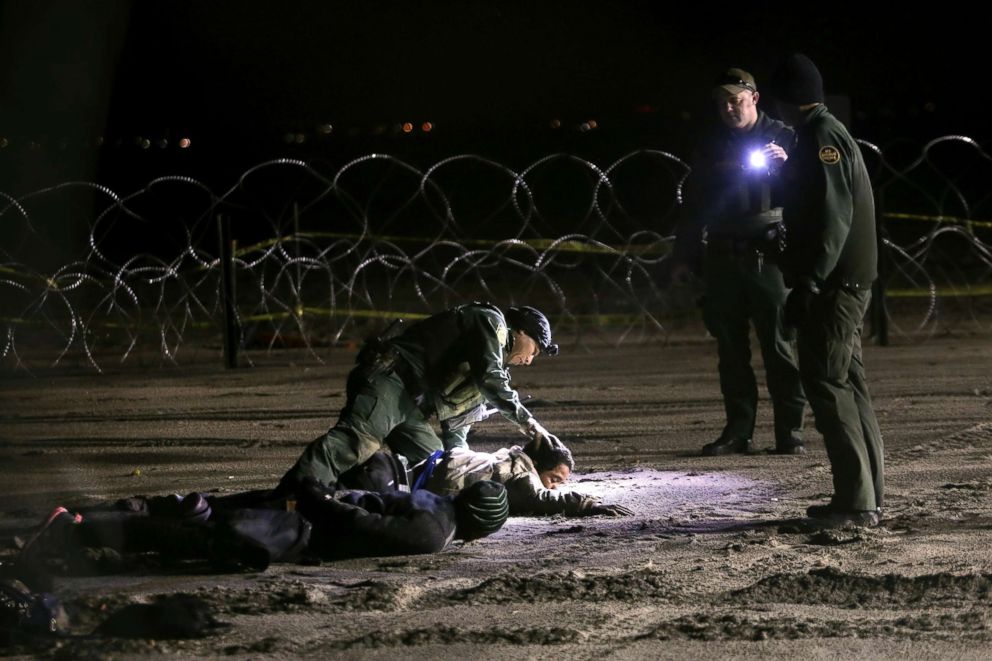 PHOTO: A U.S. Border Patrol agent pats down Honduran migrants after they crossed onto U.S territory from Tijuana, Mexico, Nov. 30, 2018.