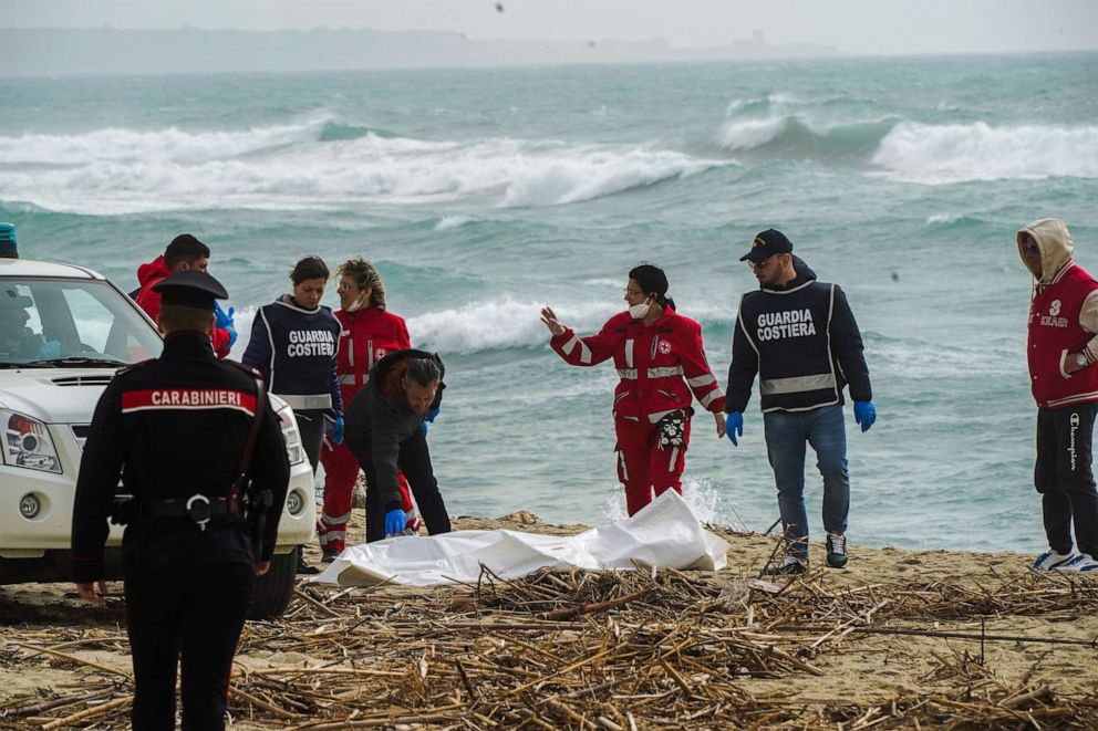 PHOTO: Italian Red Cross volunteers and coast guards recover a body after a migrant boat broke apart in rough seas, at a beach near Cutro, southern Italy, Feb. 26, 2023.