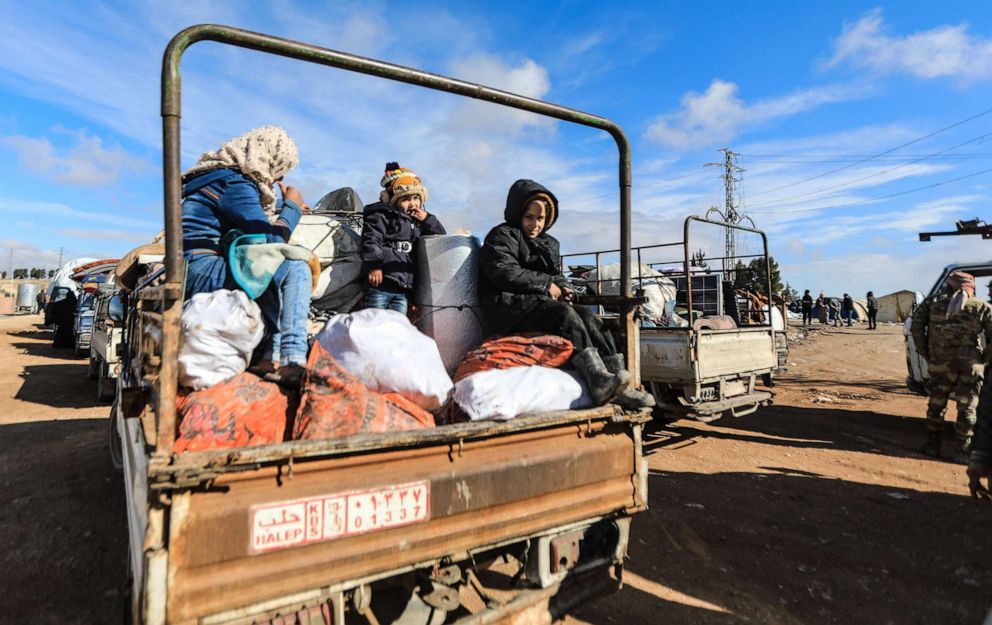 PHOTO: Internally displaced Syrians sit atop their belongings in the back of a truck at a camp, before being transported to a new housing complex in the opposition-held area of Bizaah, Feb. 9, 2022.
