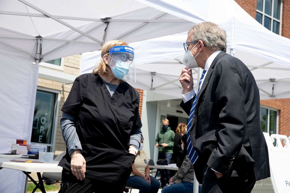 PHOTO: Nurse Carolyn Fitzpatrick speaks to Governor Mike DeWine during his visit to the Hamilton County mobile COVID-19 vaccination site at the Price Hill Library in East Price Hill, Ohio, May 7, 2021.