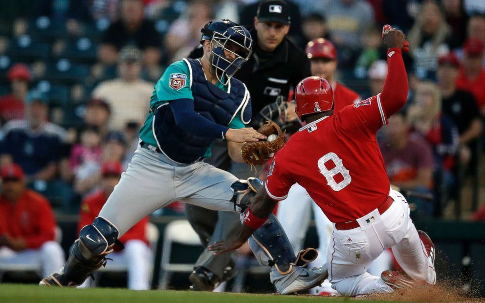 PHOTO: Seattle Mariners catcher Mike Marjama, left, tags out Los Angeles Angels left fielder Justin Upton trying to score in the first inning at Tempe Diablo Stadium.