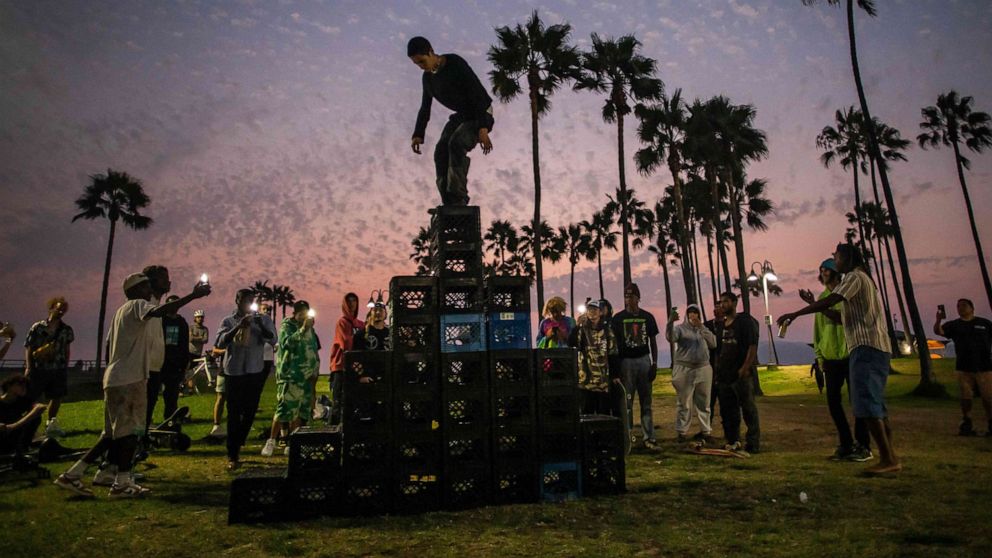 PHOTO: A man walks up a pyramid of milk crates as he takes part of the Milk Crate Challenge, in Venice, Calif., on Aug. 24, 2021.