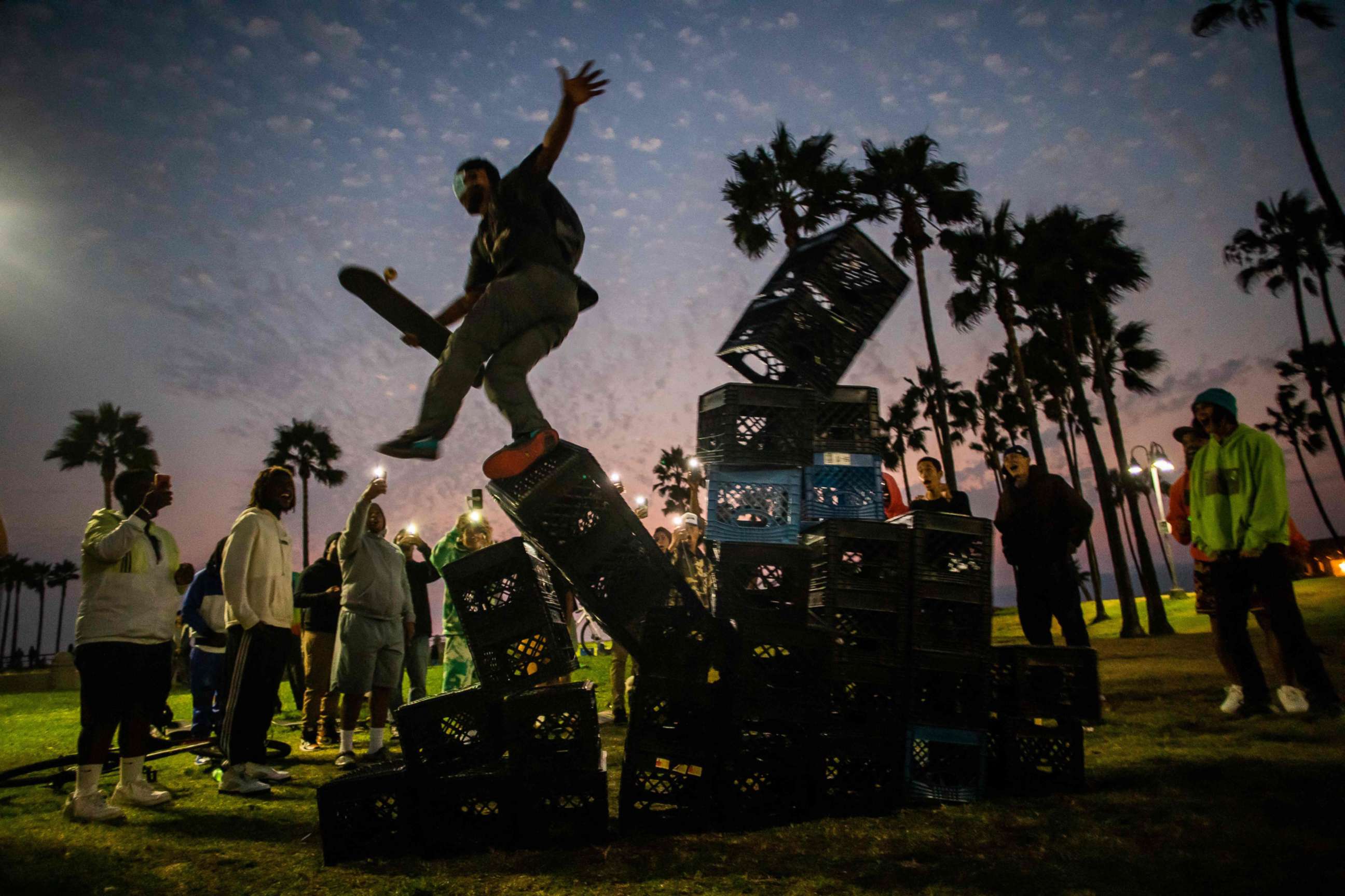 PHOTO: A man falls down of a pyramid of milk crates while he participates of the Milk Crate Challenge, on Aug. 24, 2021, in Venice, Calif.