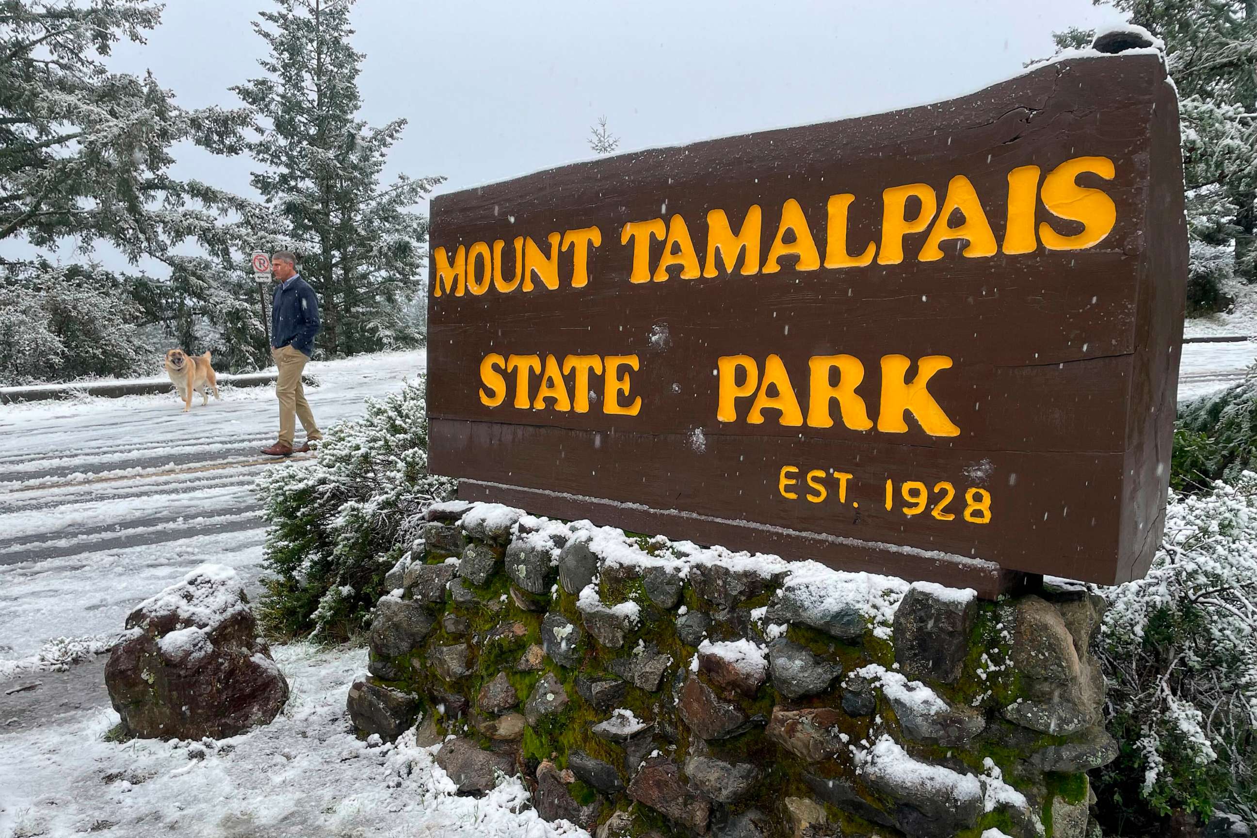 PHOTO: A man walks near the entrance to snow-covered Mount Tamalpais State Park in Mill Valley, Calif., Feb. 24, 2023.