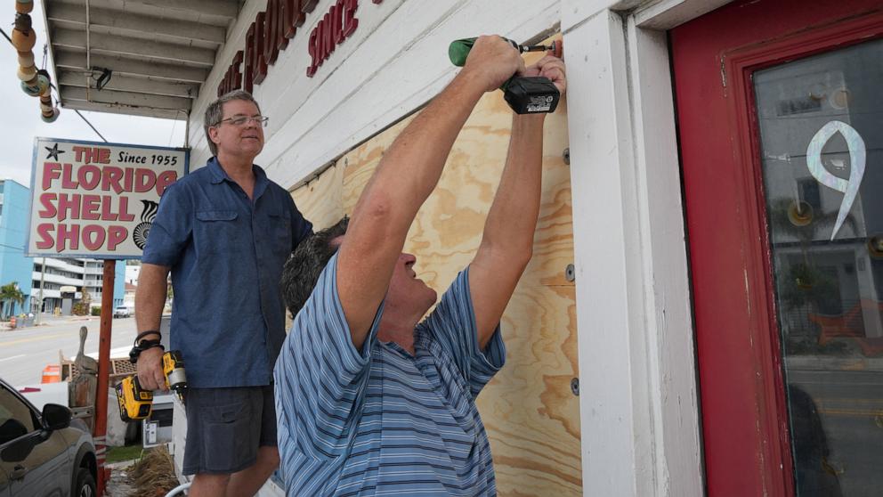 PHOTO: Residents board up a seashell store ahead of Hurricane Milton's expected landfall in the middle of this week in Treasure Island, Fla., Oct. 7, 2024. 