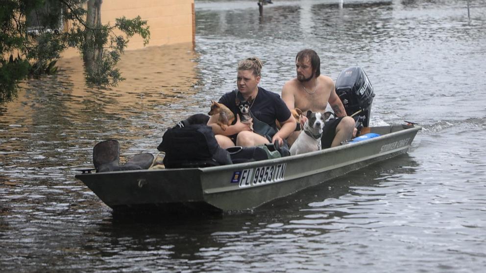 PHOTO: Residents and their pets evacuate Magnolia Avenue after Hurricane Milton flooded the neighborhood in South Daytona, Fla., Oct. 10, 2024.