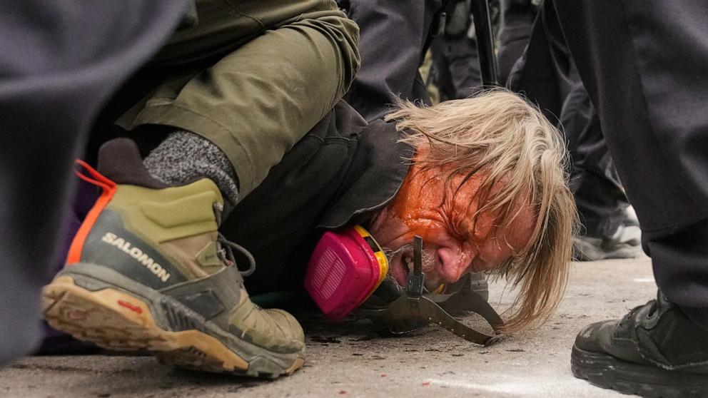 PHOTO: A man is pushed to the ground as federal immigration officers confront protesters outside Bishop Henry Whipple Federal Building, Jan. 15, 2026, in Minneapolis.