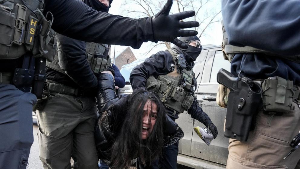 PHOTO: Federal agents detain a woman after pulling her from a car, January 13, 2026 in Minneapolis, Minnesota.