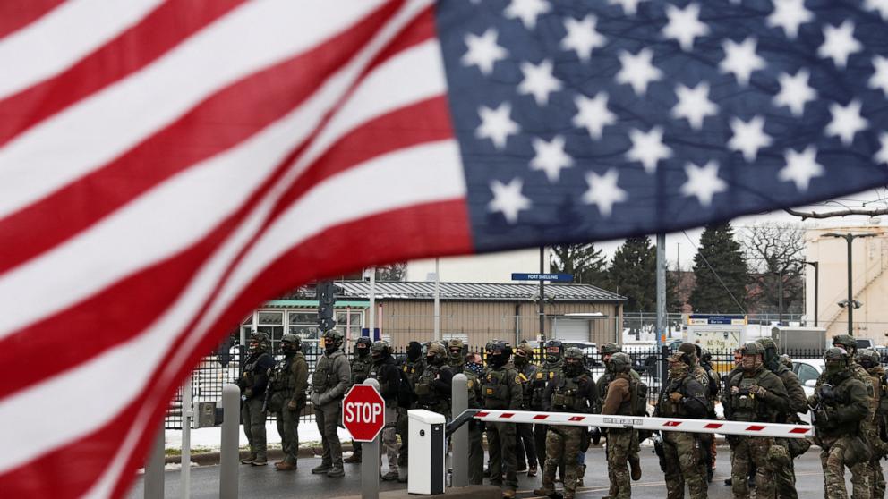 PHOTO: Homeland Security Investigations and Border Patrol stand guard, while an upside down U.S flag flutters, while demonstrators protest against the fatal shooting of Renee Nicole Good by an ICE agent in Minneapolis, Jan. 8, 2026.