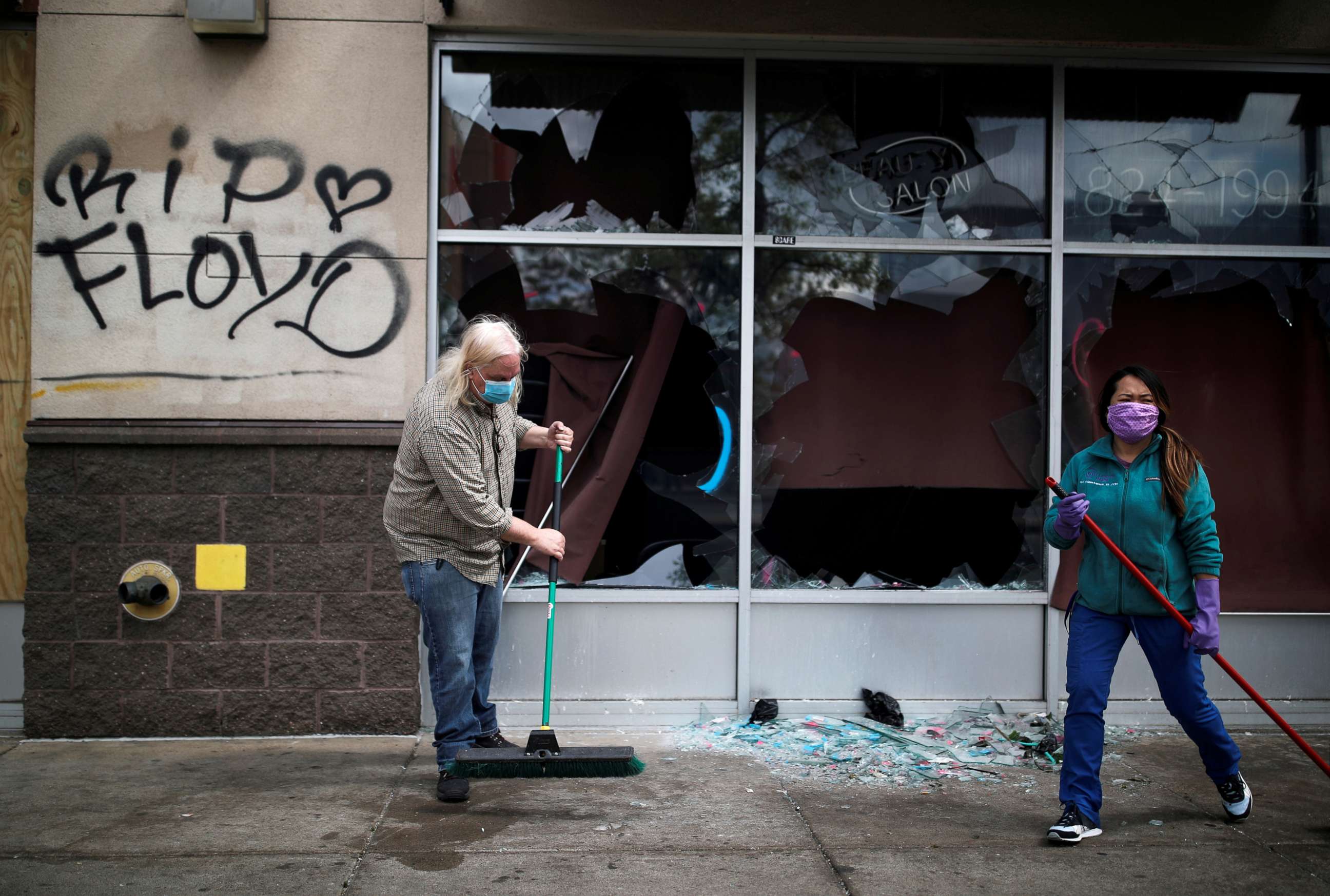 PHOTO: People clean up outside a local business in the aftermath of a protest after in Minneapolis, Minnesota, May 29, 2020.