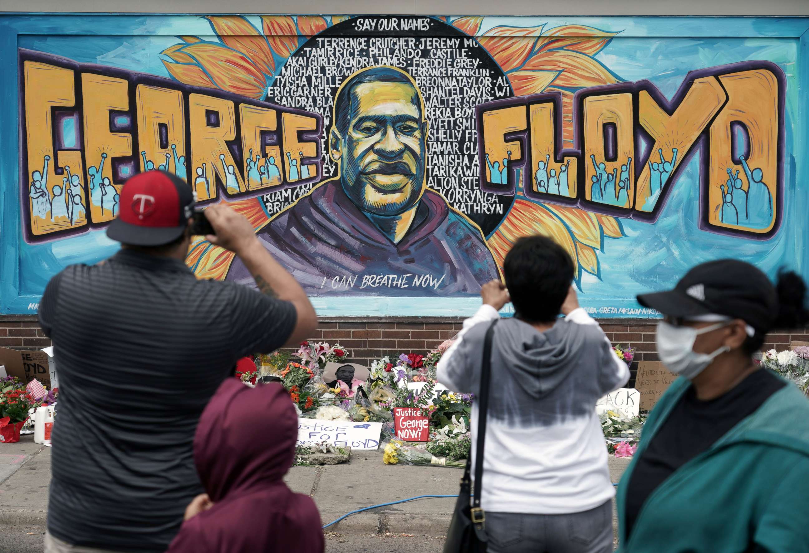 PHOTO: People gather at a memorial mural painted outside the Cup Foods store on Chicago Avenue in South Minneapolis where George Floyd died at the hands of police, Friday, May 29, 2020 in Minneapolis.