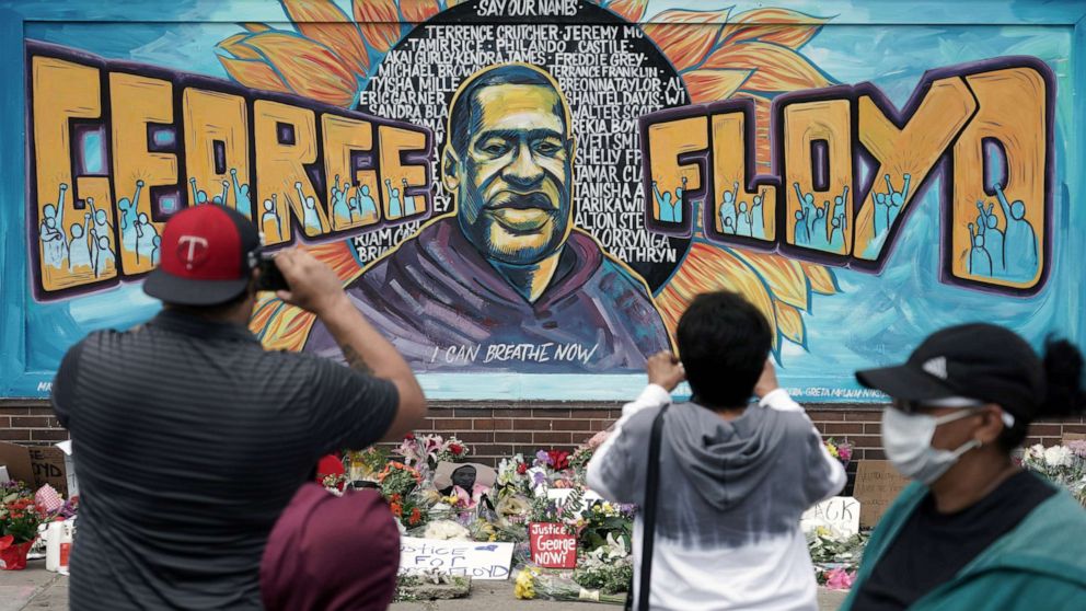 PHOTO: People gather at a memorial mural painted outside the Cup Foods store on Chicago Avenue in South Minneapolis where George Floyd died at the hands of police, Friday, May 29, 2020 in Minneapolis.