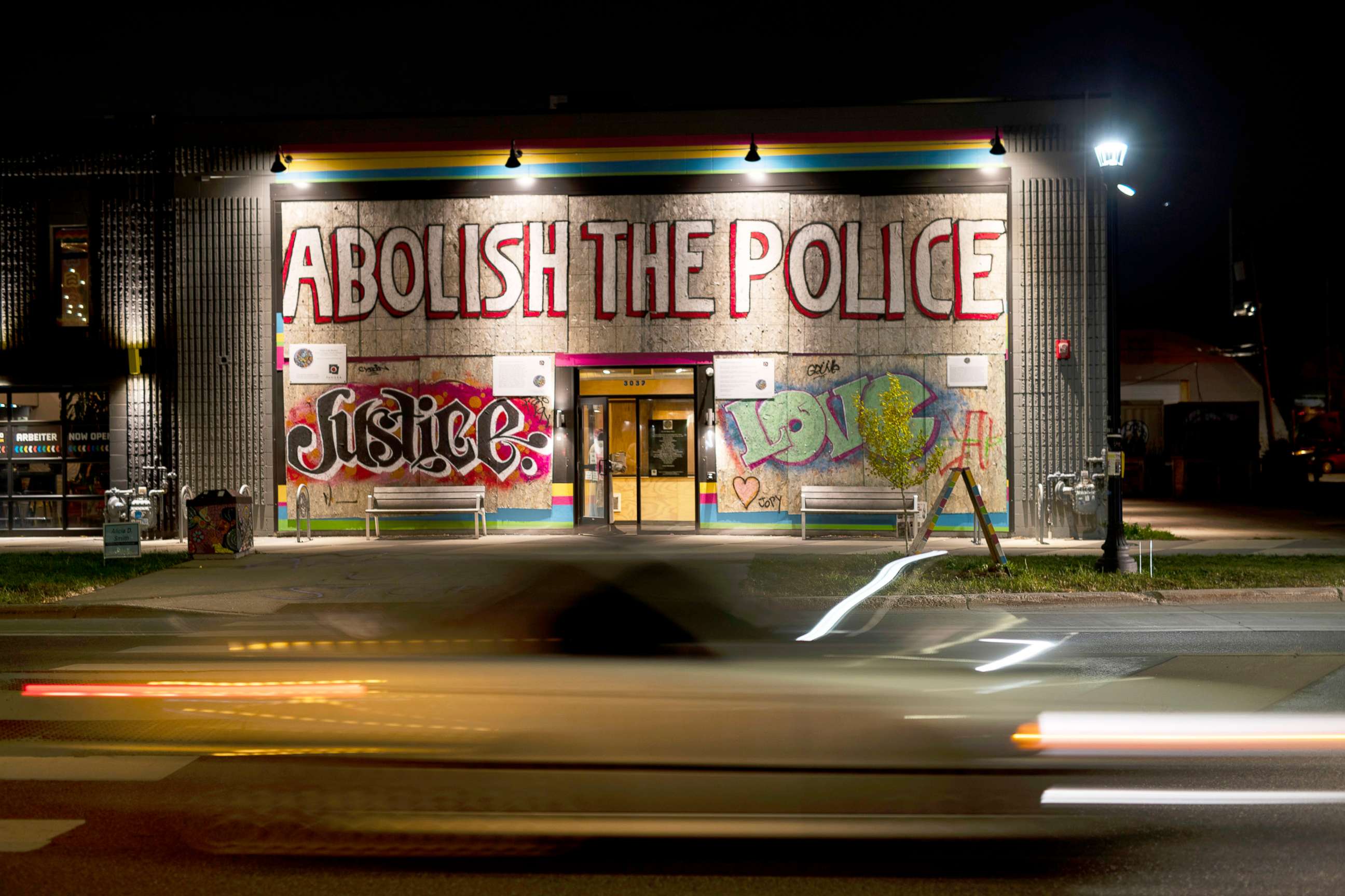 PHOTO: Traffic passes by Moon Palace bookstore adorned with a large banner reading "Abolish The Police" on Election Day in Minneapolis, Nov. 2, 2021.