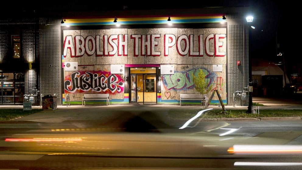 PHOTO: Traffic passes by Moon Palace bookstore adorned with a large banner reading "Abolish The Police" on Election Day in Minneapolis, Nov. 2, 2021.