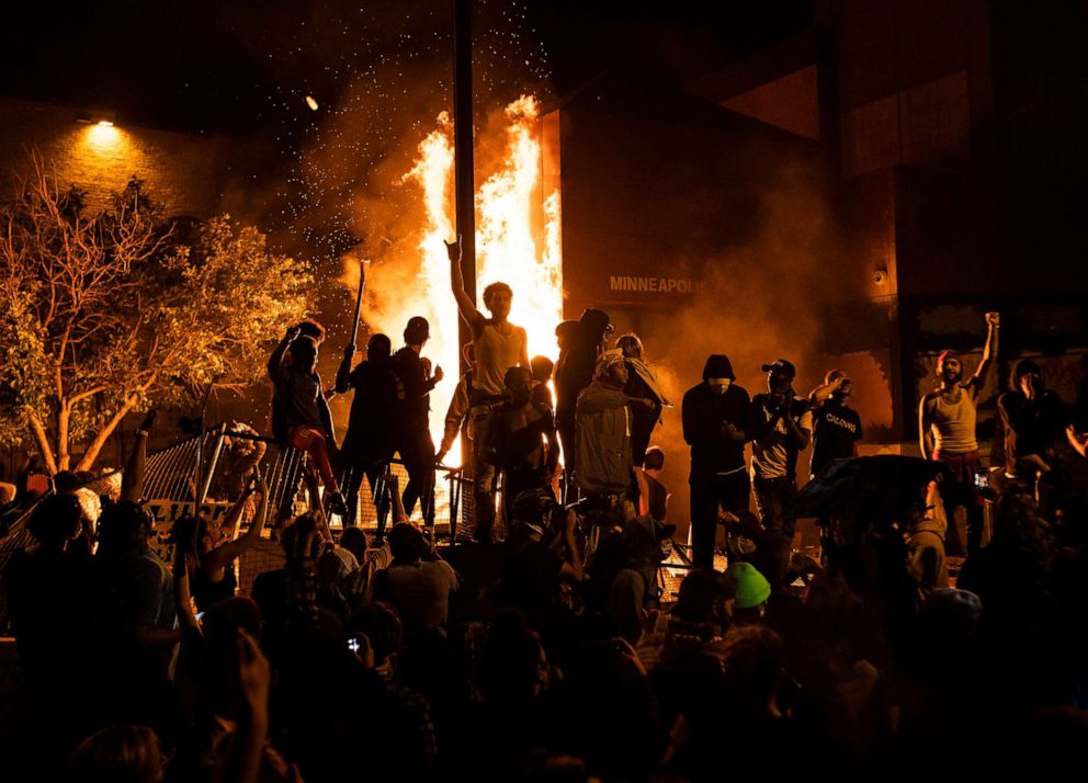PHOTO: Protesters cheer as the Third Police Precinct burns behind them on May 28, 2020 in Minneapolis, as unrest continued after the death of George Floyd.