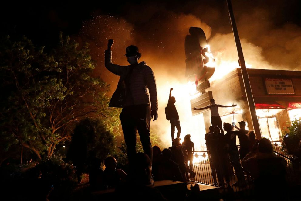 PHOTO: Protesters gather in front of a burning fast food restaurant, May 29, 2020, in Minneapolis.