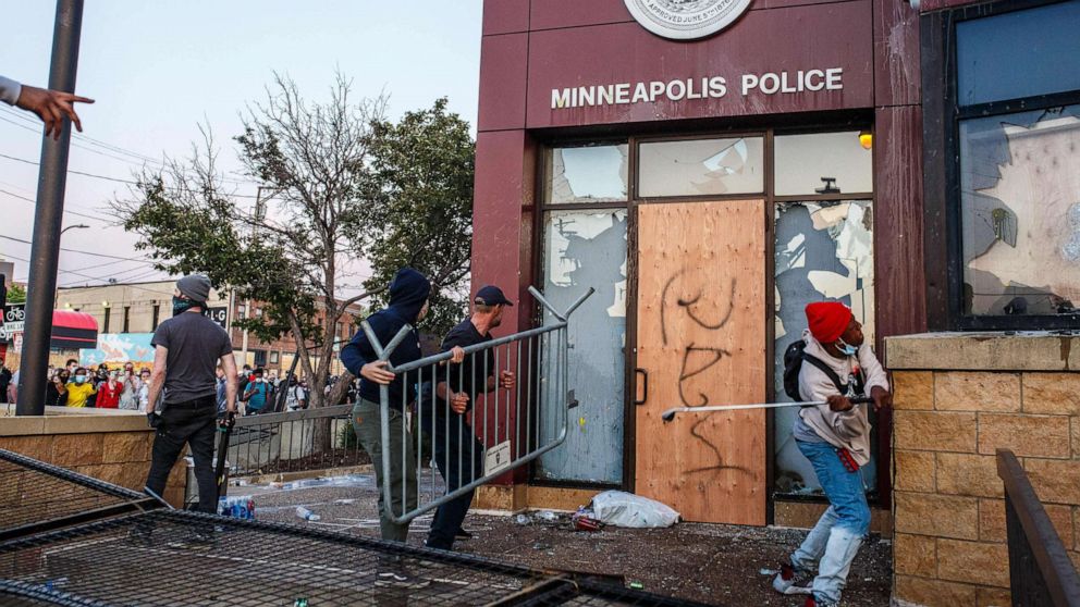 PHOTO: In this May 28, 2020, file photo, protesters use a barricade to try and break the windows of the Third Police Precinct in Minneapolis during a protest over the death of George Floyd.