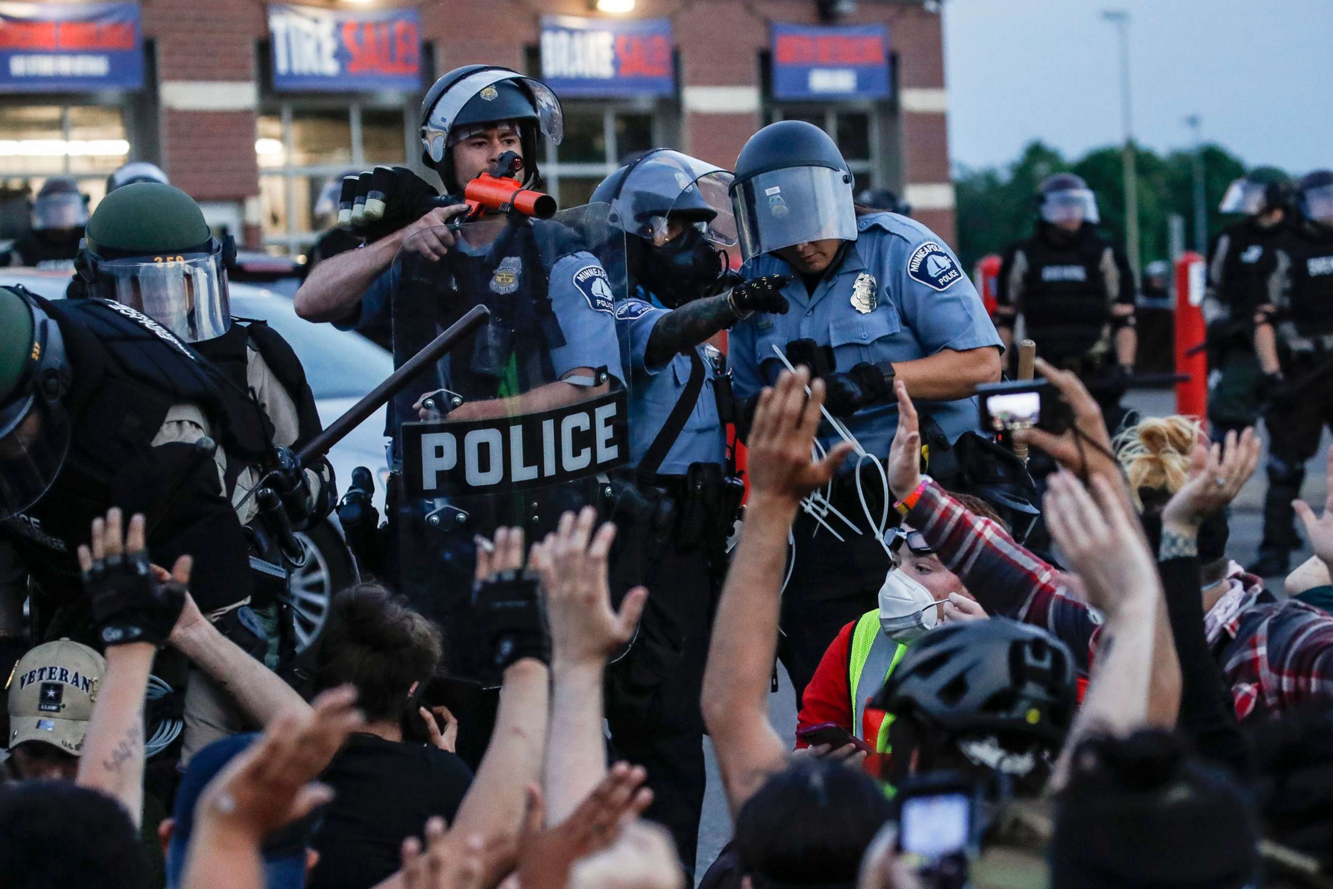 PHOTO: In this May 31, 2020, file photo, a police officer points a hand cannon at protesters who have been detained pending arrest on South Washington Street, in Minneapolis.