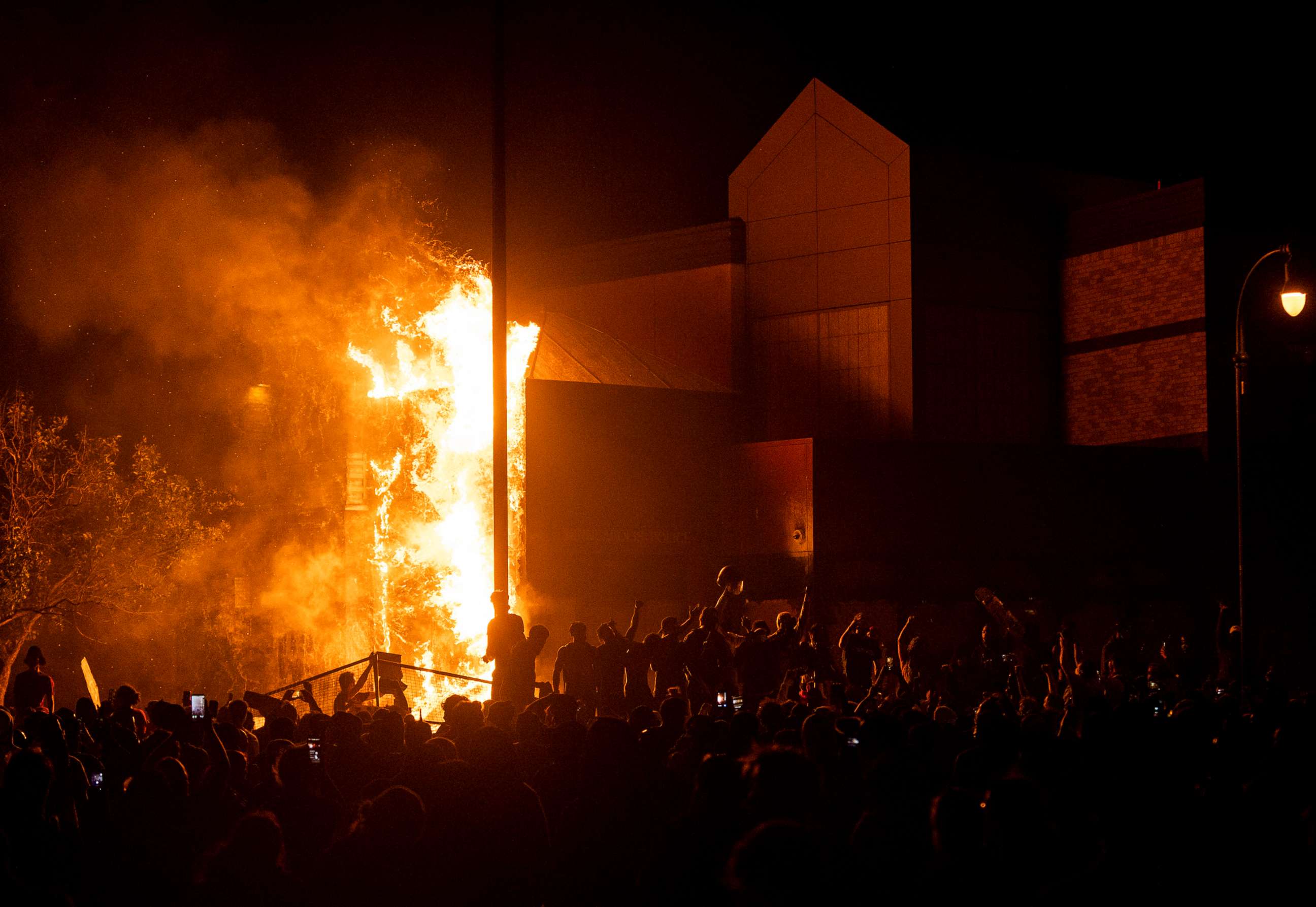 PHOTO: Protesters cheer as the Third Police Precinct burns behind them on May 28, 2020, in Minneapolis.