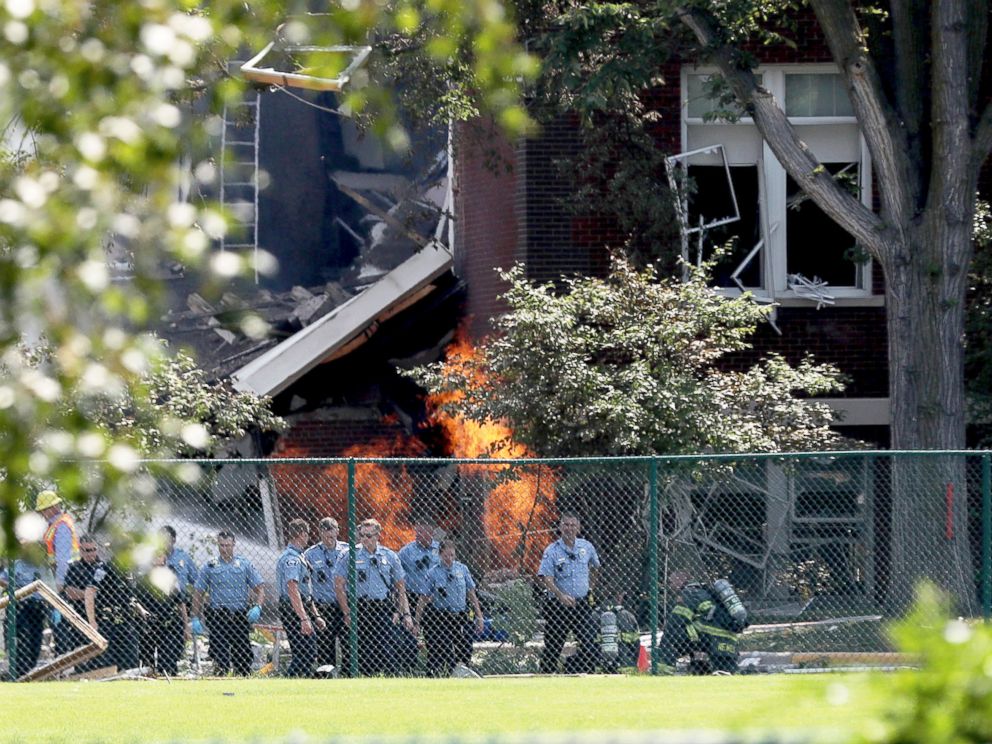 PHOTO: Emergency personnel move away as a gas fire continues to burn following an explosion at Minnehaha Academy, Aug. 2, 2017, in Minneapolis.