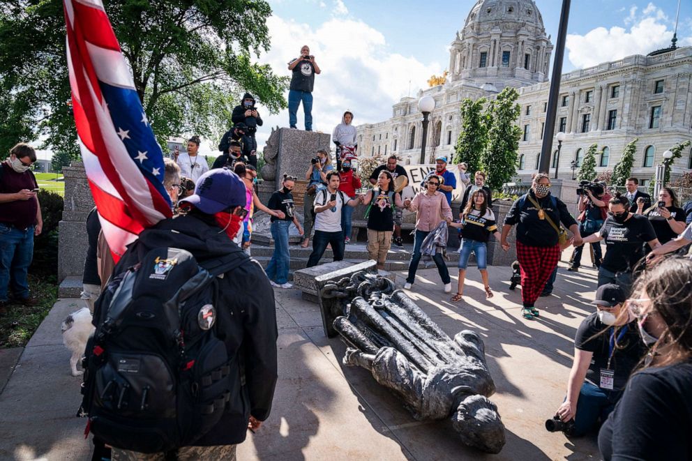 PHOTO: People dance in a circle around the Christopher Columbus statue after it was toppled in front of the Minnesota State Capitol in St. Paul, Minn., on June 10, 2020. 