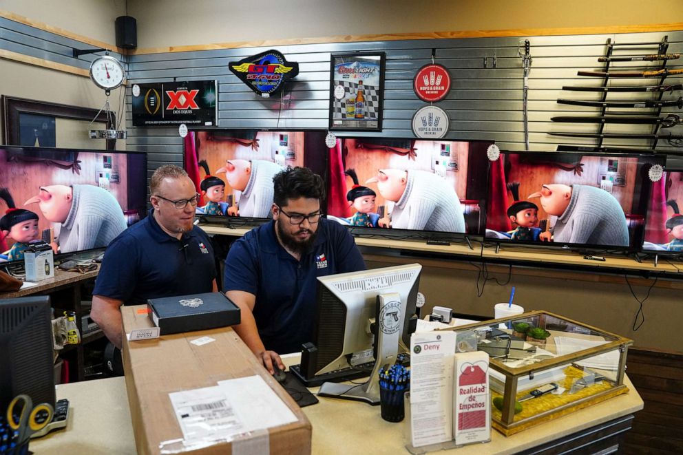 PHOTO: Employees work at pawn shop that is not enforcing the statewide mask mandate on march 3, 2021 in Leander, Texas. Texas Gov. Greg Abbott has said the mask mandate would expire on March 10.